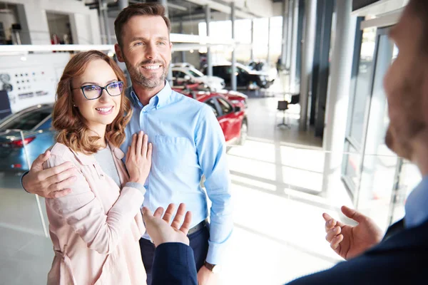 Couple et vendeur de voitures dans le magasin — Photo