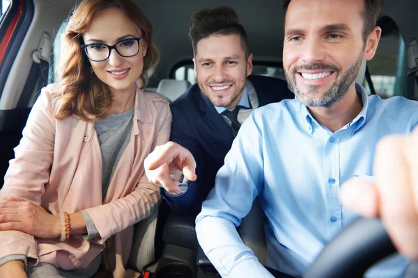 Paar en auto verkoper in de winkel — Stockfoto