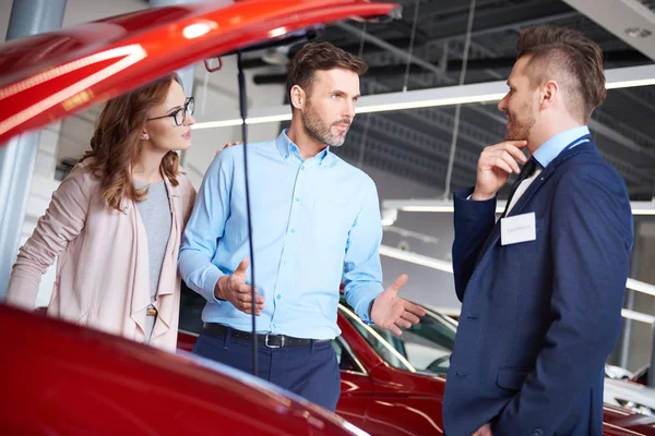 Couple and car salesman in shop — Stock Photo, Image