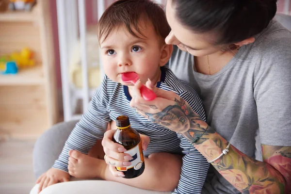 Mãe dando remédio para o bebê — Fotografia de Stock