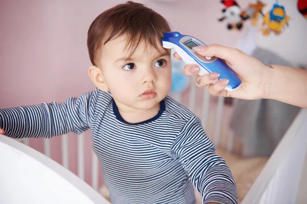 Madre comprobando la temperatura del bebé — Foto de Stock