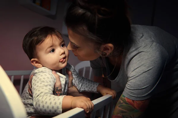 Madre por cuna de bebé en la noche — Foto de Stock