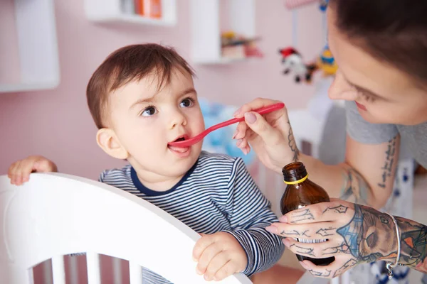 Mãe dando remédio para o bebê — Fotografia de Stock