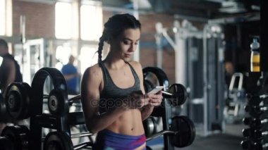 Spor salonunda cep telefonu kullanan kadın 