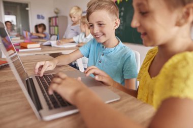 Çocuklar okulda ders sırasında dizüstü bilgisayar kullanma