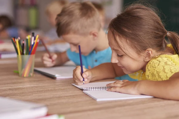 Mädchen und Junge zeichnen im Klassenzimmer — Stockfoto