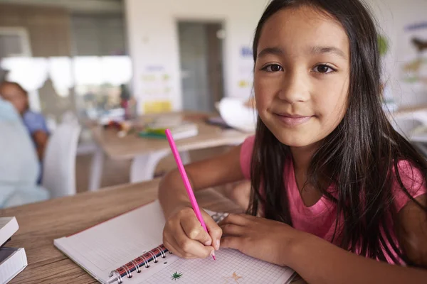 Schoolmeisje camera terwijl u zit te kijken — Stockfoto