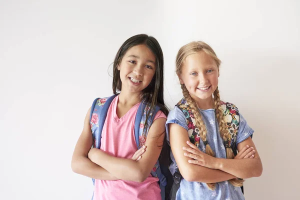 Schoolgirls with backpacks looking at camera — Stock Photo, Image