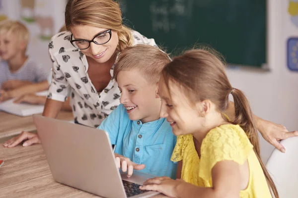 Profesor y alumnos aprendiendo con laptop — Foto de Stock