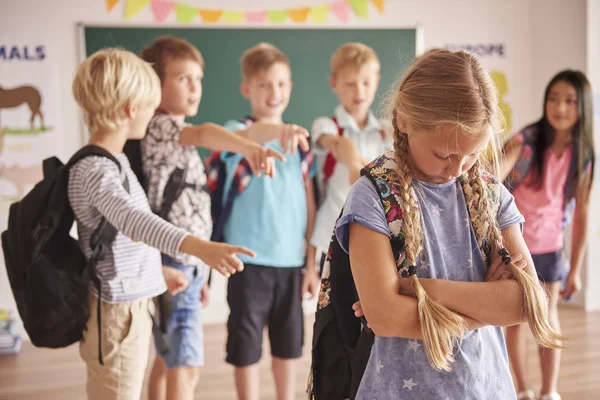 Girl standing sad in front of classmates — Stock Photo, Image