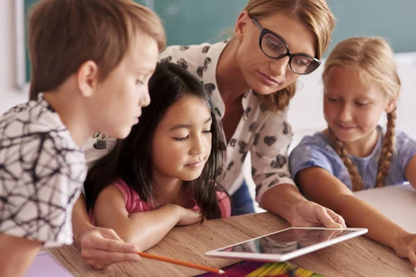 Teacher explaining to pupils with digital tablet — Stock Photo, Image