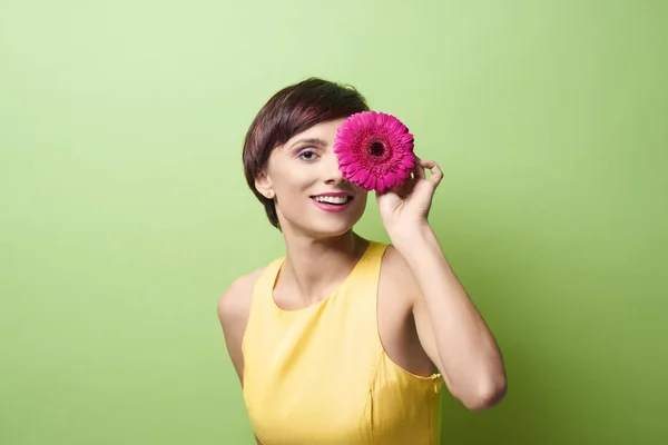 Vrouw bedrijf roze gerbera bloem — Stockfoto