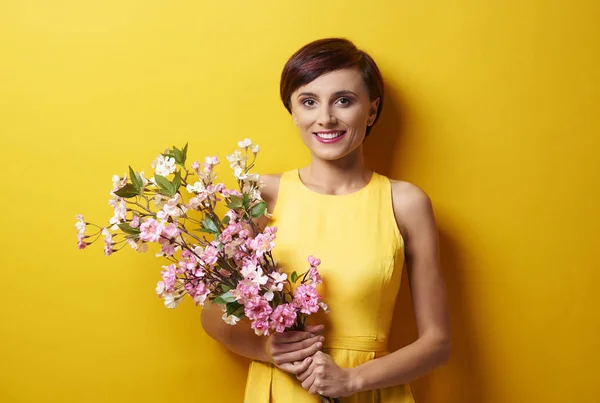 Junge Frau steht mit Blumenstrauß — Stockfoto