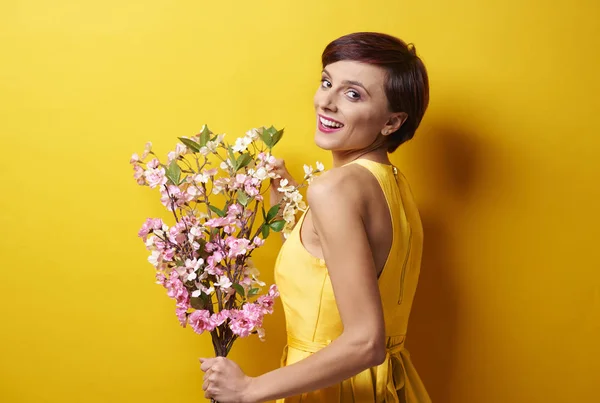 Mujer joven de pie con ramo de flores —  Fotos de Stock