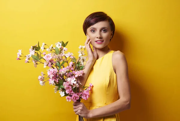 Junge Frau steht mit Blumenstrauß — Stockfoto