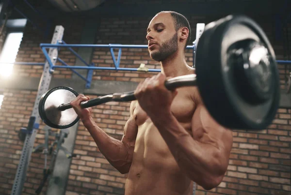 Hombre tirando de la barra en el gimnasio — Foto de Stock