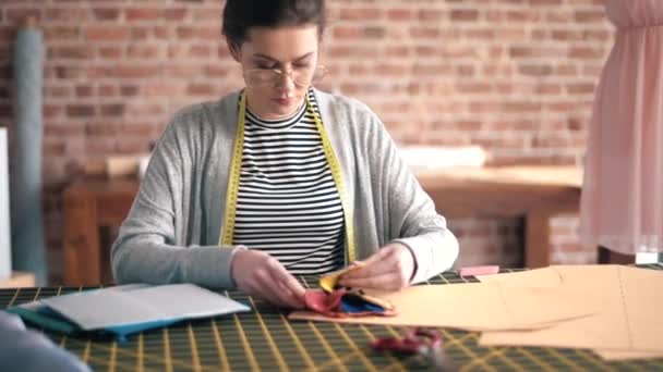 Woman examining fabric swatches in showroom — Stock Video