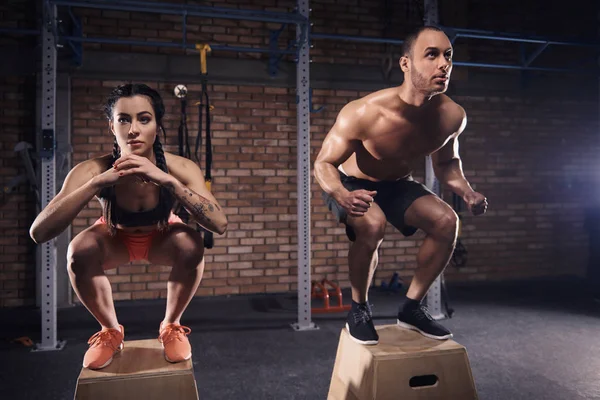 Sportig par hoppa på plattformar på gym — Stockfoto