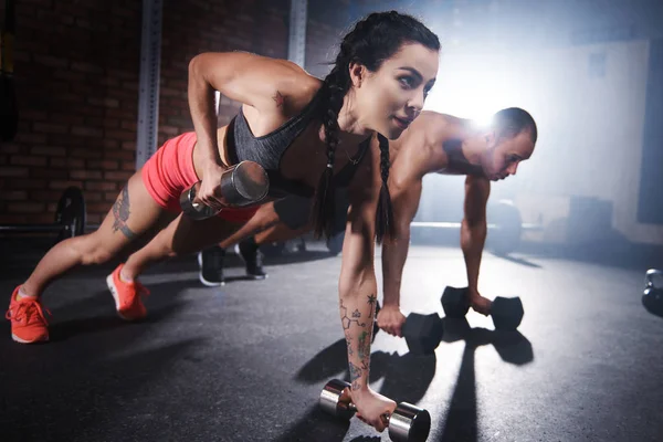 Casal fazendo flexões com halteres — Fotografia de Stock