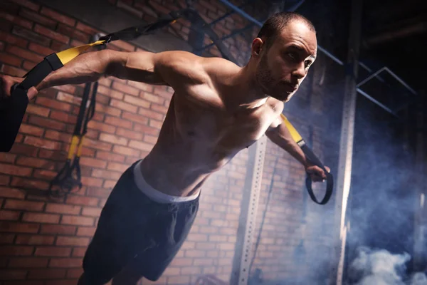 Shirtless sportsman training with resistance bands — Stock Photo, Image