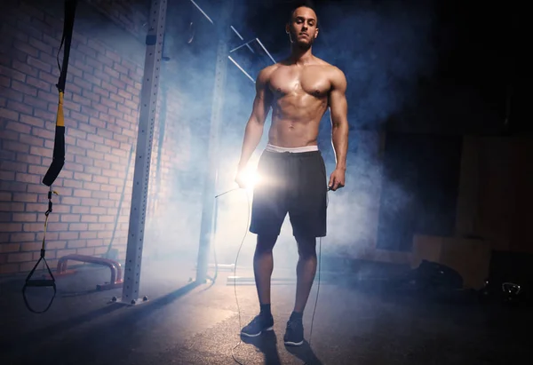Ung manlig idrottsman stående på gym — Stockfoto