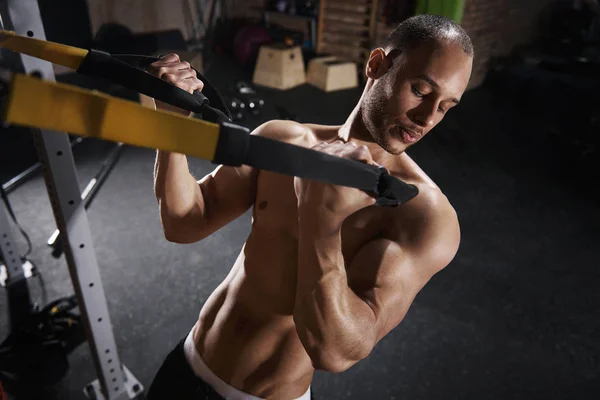 Shirtless sportsman training with resistance bands — Stock Photo, Image
