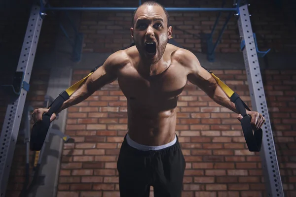 Shirtless sportsman training with resistance bands — Stock Photo, Image