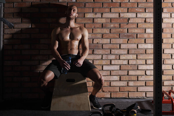 tired young athlete sitting after workout