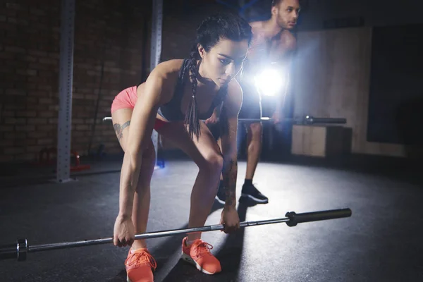 Sporty par træning med vægtstænger på gym - Stock-foto