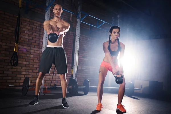 Sporty couple training with dumbbells at gym — Stock Photo, Image