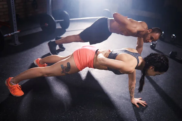 Sporty couple doing push ups — Stock Photo, Image