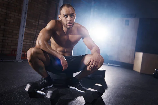 Sportovní muž sedící v tělocvičně — Stock fotografie