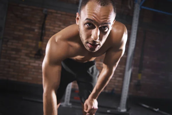 Deportista de entrenamiento en el gimnasio y mirando a la cámara — Foto de Stock