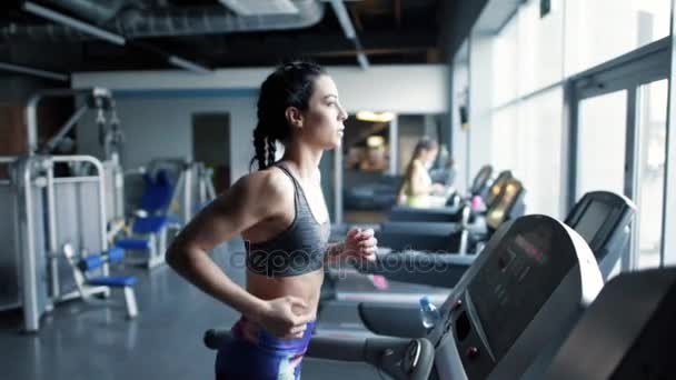 Sportig kvinna kör på löpband på gym — Stockvideo