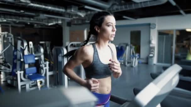 Sportliche Frau läuft im Fitnessstudio auf Laufbändern — Stockvideo