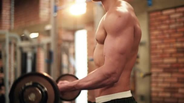 Strong man lifting barbell at gym — Stock Video