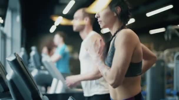 Entrenamiento en pareja en la máquina elíptica en el gimnasio — Vídeo de stock