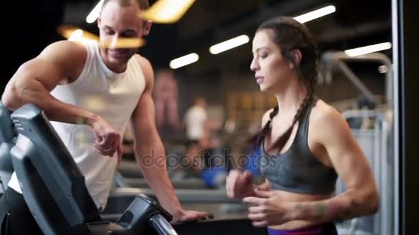 Entrenamiento en pareja en la máquina elíptica en el gimnasio — Vídeos de Stock