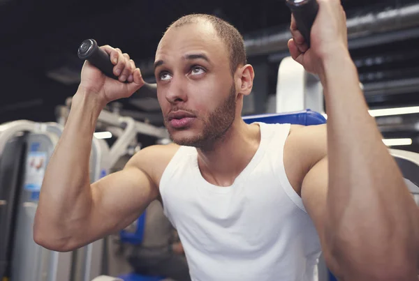 Hombre haciendo entrenamiento con máquina de ejercicio — Foto de Stock