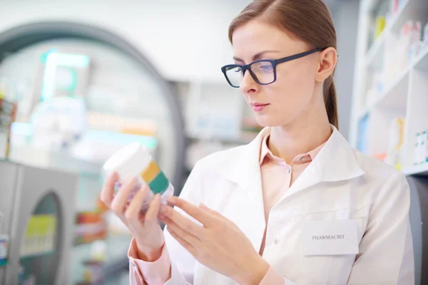 Apotheker überprüft Arzneimittel-Etikett auf Flasche — Stockfoto