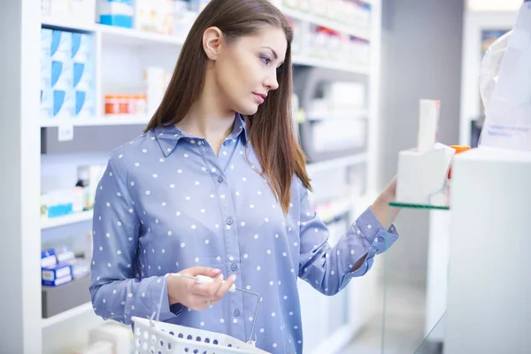Mujer joven comprando medicamentos en la tienda de salud — Foto de Stock