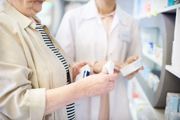 Pharmacist advising senior woman on medicine — Stock Photo, Image