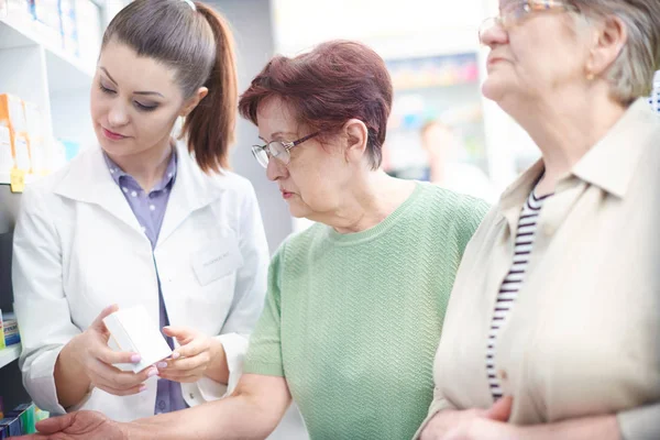 Patienter jämföra priser med apotekspersonal — Stockfoto