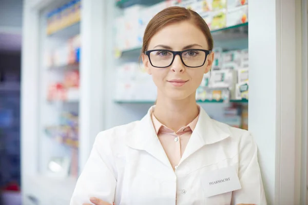 Молодий фармацевт стоїть в аптеці — стокове фото