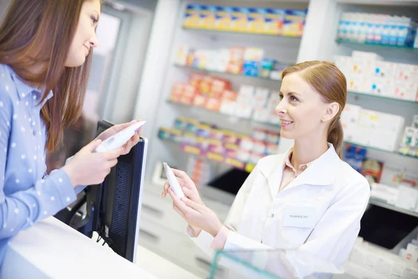 Vrouwelijke apotheker adviseren met geneeskunde — Stockfoto