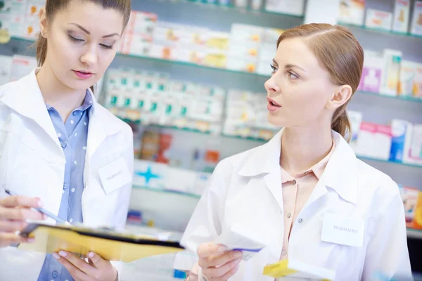 Dos farmacéuticos escribiendo en portapapeles — Foto de Stock