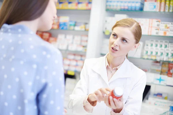 Фармацевт розмовляє з клієнтом жінки — стокове фото