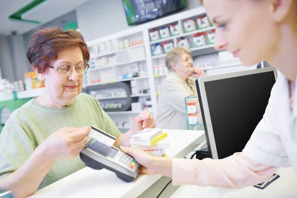 Клиент оплачивает кредитной картой в аптеке — стоковое фото