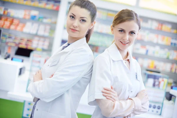 Two attractive pharmacists in pharmacy — Stock Photo, Image