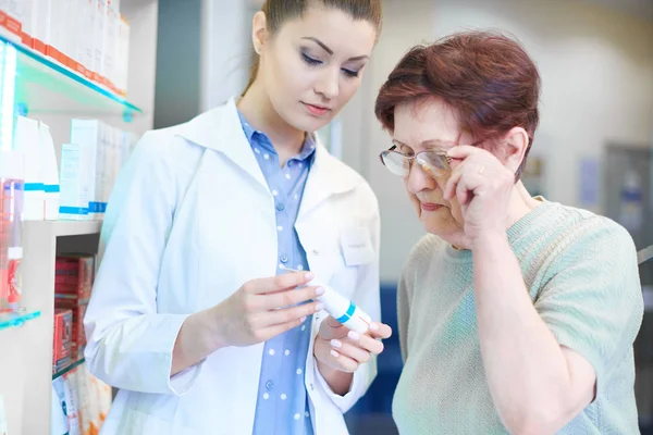 Farmacéutica ayudando a la mujer adulta mayor de compras — Foto de Stock